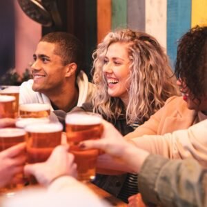 Friends drinking and toasting with beer at pub
